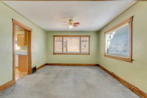 Carpeted empty room featuring ceiling fan