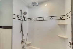 Bathroom featuring tiled shower / bath and ornamental molding