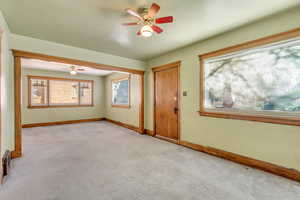 Carpeted empty room with ceiling fan