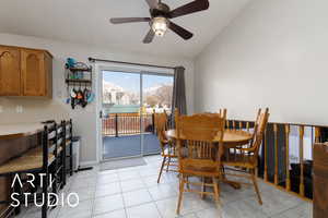 Tiled dining room with a mountain view, ceiling fan, and lofted ceiling