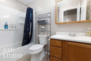 Full bathroom with toilet, shower / bath combination with curtain, and vanity