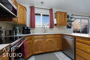 Kitchen with sink, light tile patterned flooring, and stainless steel appliances