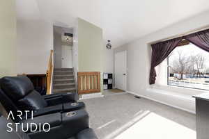 Carpeted living room with vaulted ceiling