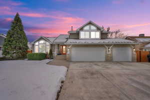 Winter View of front of house with a garage