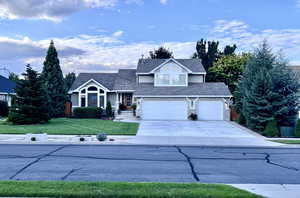 Summer View of front of house with a garage and a front lawn