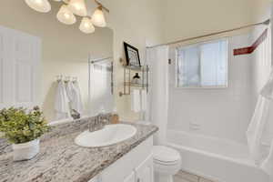 Full bathroom featuring shower / bath combo, toilet, tile patterned flooring, and vanity