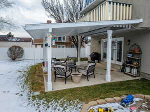 Snow covered patio with a grill