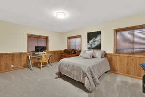 Bedroom featuring light colored carpet and a textured ceiling