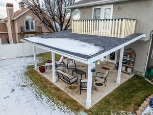 Snow covered patio with a balcony