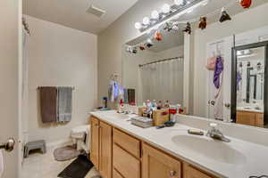 Bathroom with a textured ceiling, toilet, and vanity