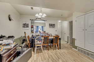 Dining room featuring light wood-type flooring and a chandelier