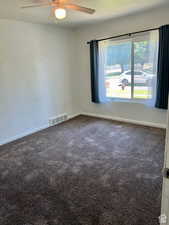 Carpeted empty room with ceiling fan