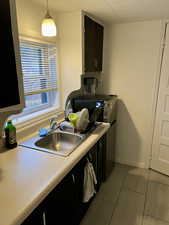 Kitchen featuring stove, hanging light fixtures, and sink