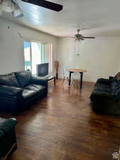 Living room featuring ceiling fan and dark hardwood / wood-style flooring