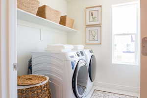 Laundry room with washing machine and clothes dryer and tile patterned floors