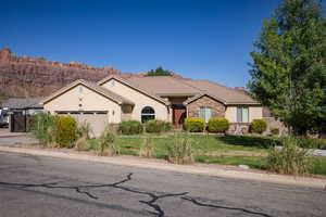 View of front of house with a garage, a front yard, and a mountain view