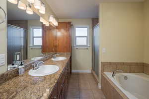 Bathroom with vanity, a wealth of natural light, separate shower and tub, and tile patterned flooring