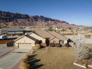 Ranch-style home with a garage, a mountain view, and a front yard