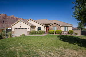 View of front of house with a garage, a mountain view, and a front lawn