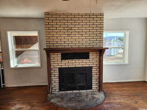 Interior details featuring a textured ceiling, a fireplace, and wood-type flooring