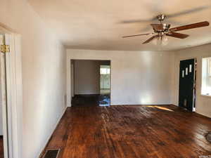 Empty room with dark hardwood / wood-style floors and ceiling fan