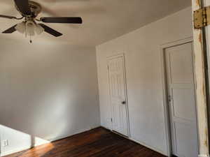 Unfurnished bedroom featuring dark hardwood / wood-style floors and ceiling fan