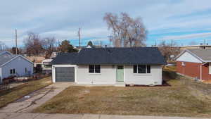 Single story home with a garage and a front lawn