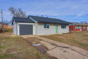 Ranch-style house featuring a garage and a front lawn