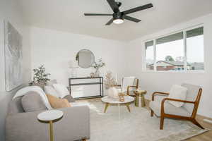 Sitting room with ceiling fan and wood-type flooring