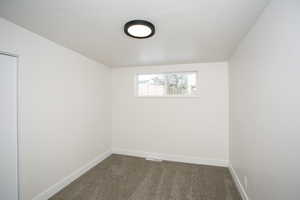 Carpeted empty room featuring a textured ceiling