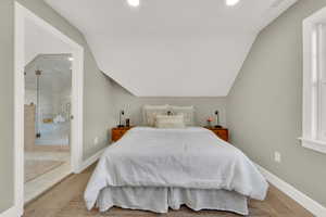 Bedroom with light hardwood / wood-style flooring and vaulted ceiling