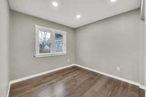 Empty room with dark hardwood / wood-style flooring