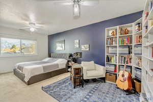 Bedroom featuring ceiling fan, a textured ceiling, and carpet floors