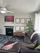 Living room with ceiling fan and a textured ceiling