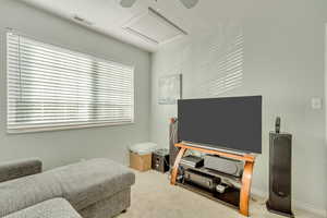 Sitting room featuring ceiling fan and carpet