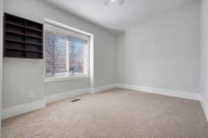 Unfurnished room featuring carpet flooring and ceiling fan