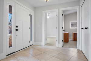 Foyer entrance featuring light tile patterned flooring