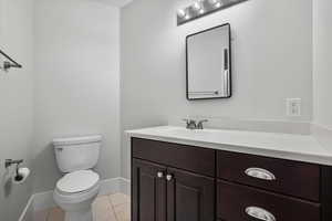 Bathroom featuring vanity, toilet, and tile patterned flooring