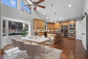 Dining area featuring sink, dark hardwood / wood-style floors, a barn door, and ceiling fan