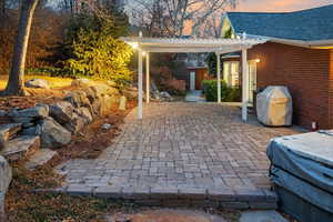 Patio terrace at dusk with a shed, grilling area, and a pergola