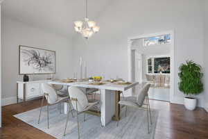 Dining room with high vaulted ceiling, dark wood-type flooring, and a chandelier