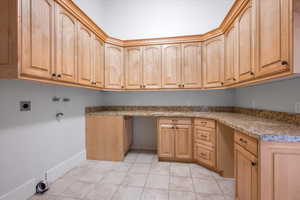 Laundry room with electric dryer hookup, hookup for a washing machine, and cabinets