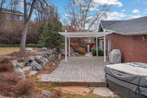 View of patio with a grill, a storage unit, and a pergola