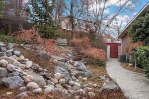 View of yard with cooling unit and a storage shed