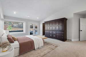 Carpeted bedroom with french doors, lofted ceiling, a textured ceiling, and access to outside