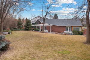 Rear view of house with french doors, a pergola, and a yard