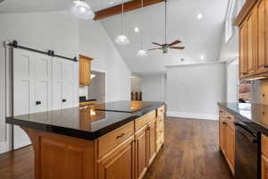 Kitchen with decorative light fixtures, dark hardwood / wood-style floors, a kitchen island, ceiling fan, and black appliances