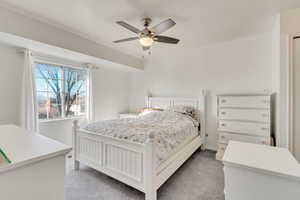 Carpeted bedroom with ceiling fan