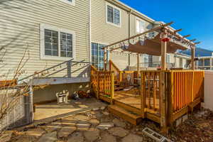 Wooden deck featuring central air condition unit and a pergola