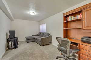 Carpeted office space with a textured ceiling